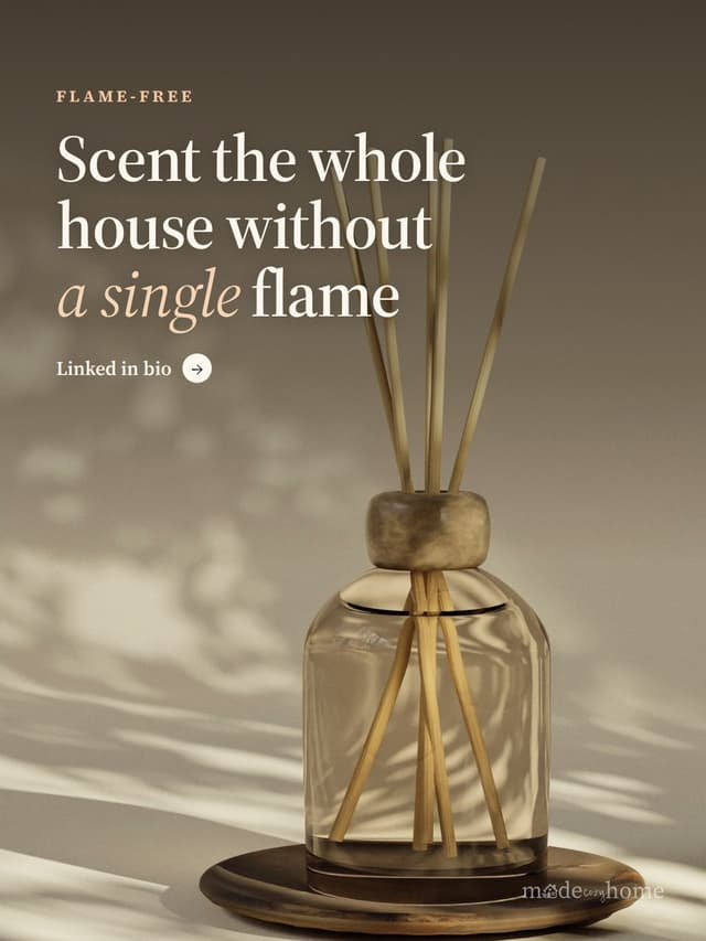 A reed diffuser sits on a wooden plate