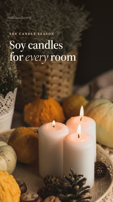 white pillar candle between orange pumpkins